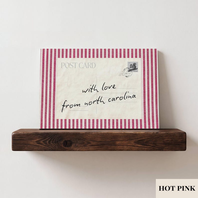 May include: A rectangular postcard print featuring a cream-colored center with the text "POST CARD" and "with love from north carolina" in black script, accented by a small squirrel stamp and postmark, framed by a hot pink and white striped border.