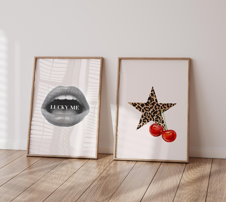 May include: Two framed prints, one with a black and white illustration of a pair of lips with the text "LUCKY ME" and the other with a black star with a leopard print pattern and two red cherries.