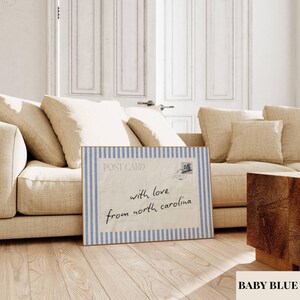 May include: A rectangular print featuring a postcard design with a light blue and white vertical striped border. The center displays the text POST CARD and the handwritten message with love from north carolina, along with a small postage stamp graphic.