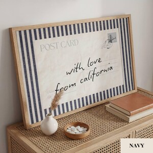 May include: A rectangular framed wall art piece featuring a vintage postcard design with navy blue and white vertical stripes. The print displays the text POST CARD and the handwritten script with love from california, alongside a small stamp graphic.