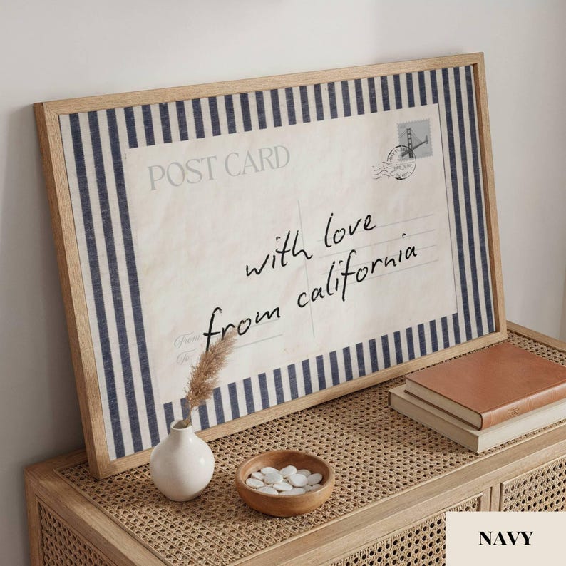 May include: A rectangular framed wall art piece featuring a vintage postcard design with navy blue and white vertical stripes. The print displays the text POST CARD and the handwritten script with love from california, alongside a small stamp graphic.