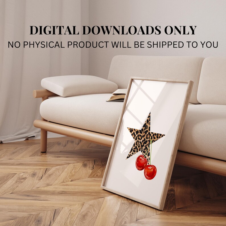 May include: A digital download print featuring a leopard print star with two red cherries hanging from it. The print is framed and displayed on a white couch.