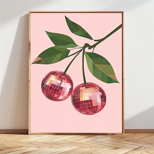 May include: A framed art print featuring two cherries with a disco ball effect. The cherries are red with a mosaic pattern, hanging from a green stem with green leaves against a light pink background.