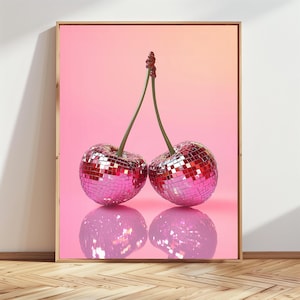 Könnte beinhalten: Gerahmter Druck mit zwei Kirschen, die jeweils aus einem Mosaik aus reflektierenden, rosa Discokugel-Kacheln gefertigt sind. Die Kirschen sind durch grüne Stiele auf einem rosa Farbverlaufshintergrund verbunden, mit einer Spiegelung darunter.