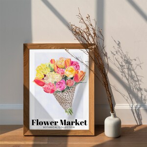 May include: A framed print featuring a watercolor bouquet of colorful tulips in shades of yellow, pink, and orange. The bouquet is presented in a dotted cone. The text "Flower Market Botanical Collection" is displayed at the bottom.