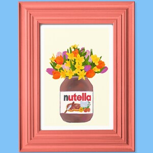 May include: A framed art print featuring a jar of Nutella filled with a bouquet of colorful flowers. The flowers include orange tulips, yellow daffodils, and purple flowers. The frame is a coral color, set against a light blue background.