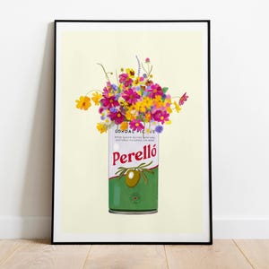 May include: A framed art print showing a colourful floral arrangement in a green and white Perelló olive oil tin. The tin features the Perelló logo and an olive branch illustration. The background is a pale yellow.