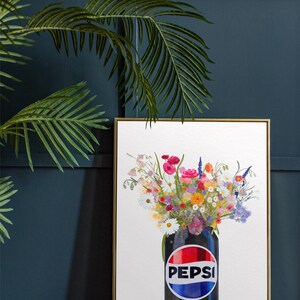 May include: Framed art print featuring a black Pepsi Max can filled with a vibrant bouquet of colorful flowers. The can's logo is prominently displayed. The artwork is set against a white background and framed in gold.