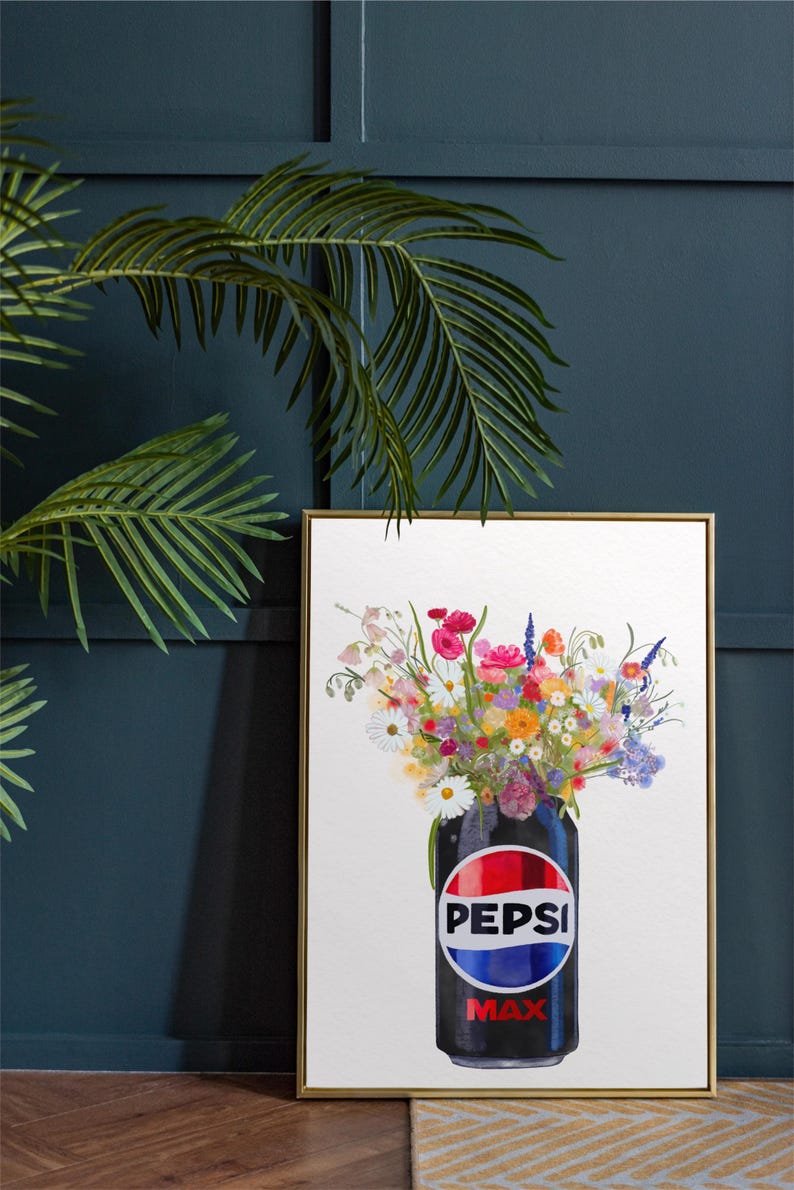 May include: Framed art print featuring a black Pepsi Max can filled with a vibrant bouquet of colorful flowers. The can's logo is prominently displayed. The artwork is set against a white background and framed in gold.