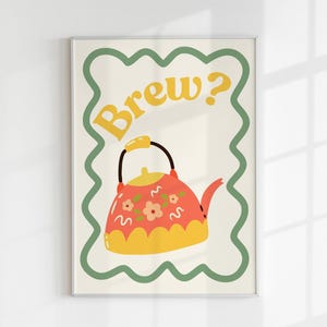 May include: A white framed print with a green border and a red and yellow teapot with flowers on it. The text "Brew?" is in yellow letters on the print.