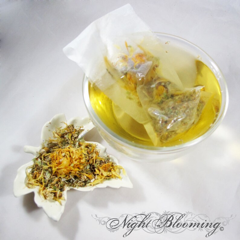 May include: A clear glass bowl filled with yellow liquid, with a tea bag steeping inside. A white leaf-shaped dish holds dried herbs and flower petals. The image is set against a white background. The text "Night Blooming" is at the bottom.