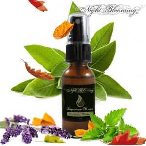 May include: A brown glass bottle with a black spray top and a label that reads "Night Blooming Signature Mister Custom Mist 1 oz". The bottle is surrounded by green leaves, lavender flowers, and orange and red leaves.