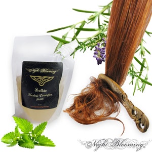 Puede incluir: Una bolsa de plástico transparente con una etiqueta que dice "Selkie Herbal Detangler (Refill)" de Night Blooming. La bolsa está llena de un líquido amarillo claro. La imagen también muestra un peine de madera con un diseño tallado, un mechón de cabello rojo y varias hierbas, incluyendo romero, lavanda y menta.