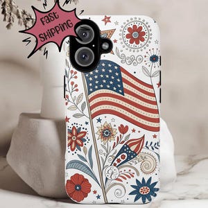 May include: A white phone case featuring an American flag design with red, white, and blue floral and star accents. The case has a camera cutout and the words "Fast Shipping" in a pink burst.