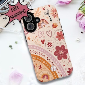Puede incluir: Una funda de teléfono con un diseño floral y arcoíris en tonos melocotón, naranja y rojo. La funda presenta corazones, estrellas y otros elementos decorativos. La funda del teléfono tiene un módulo de cámara negro.