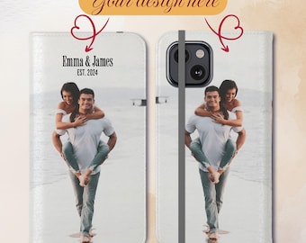 May include: A white phone case featuring a couple on a beach. The case has a flap that covers the phone screen and a strap to keep it closed. The text "Emma & James EST. 2024" is printed on the front of the case.