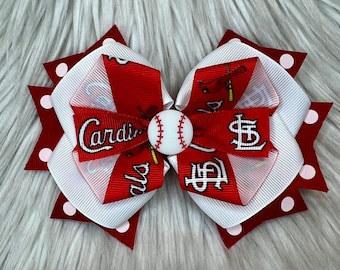 Könnte beinhalten: Rotes und weißes Haarband mit einem Baseball und den Worten "Cardinals" und "St. Louis" darauf.