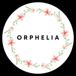 May include: A circular white sticker featuring the name ORPHELIA in bold black capital letters at the center. The text is surrounded by a delicate watercolor wreath composed of light pink five-petaled flowers and thin green leaves.