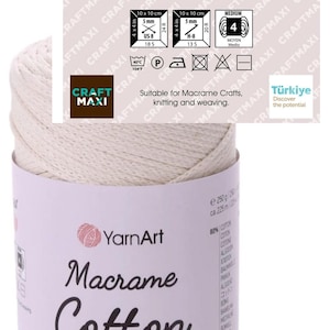 May include: A spool of off-white YarnArt Macrame Cotton cord with a paper label. The label displays 80% Cotton, 20% Polyester, 250 g, 8.80 oz, 225 m, and 246.06 yds. It includes care icons, a size 4 knitting needle symbol, and text for crafting.