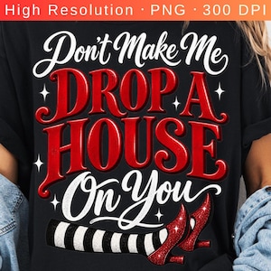Op de afbeelding: Een zwart t-shirt met de witte en rode tekst Don't Make Me DROP A HOUSE On You. Het ontwerp bevat een afbeelding van twee benen met zwart-wit gestreepte kousen en rode glitterende hoge hakken onderaan de tekst.