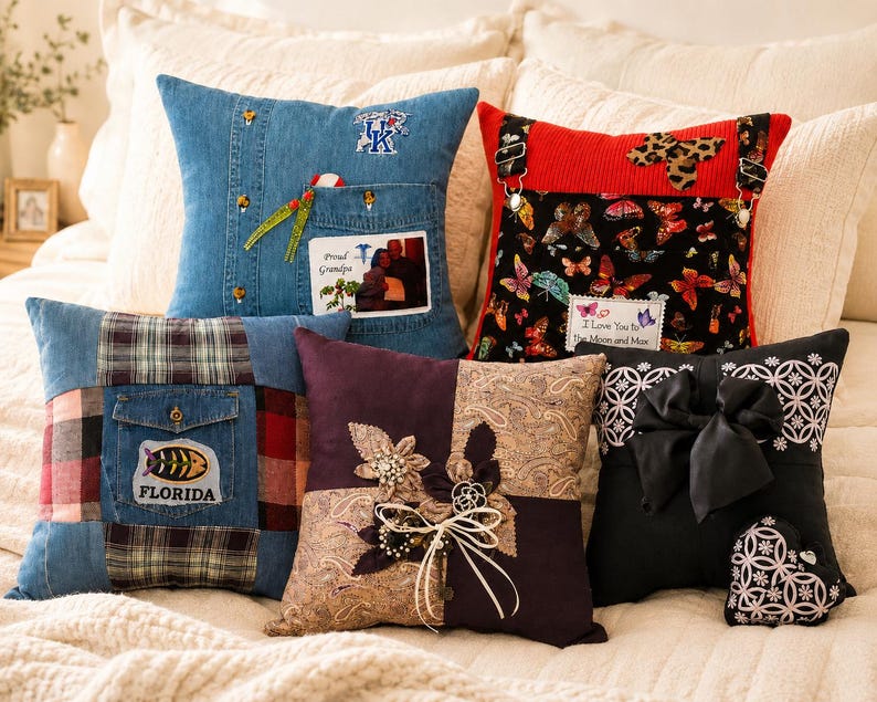 A collection of decorative memory throw pillows made from clothing with unique designs. Pillows include denim, plaid, and butterfly patterns. One pillow features a photo and text that reads "Proud Grandpa". Another has a black bow.