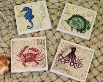 May include: Set of four ceramic coasters featuring vintage nautical illustrations. The coasters depict a blue seahorse, a green fish, a red crab, and a purple octopus. Each coaster has a beige background with a vintage map design.
