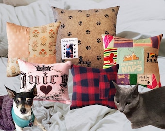 May include: A collection of decorative throw pillows featuring various patterns, including a tan paw print design with a memorial photo, a pink pillow with a crown and heart, a red and black plaid pillow, and a colorful patchwork design.