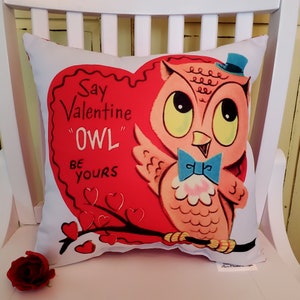 May include: A white pillow with a red heart-shaped design featuring a pink owl wearing a blue bow tie and a blue top hat. The text on the heart reads "Say Valentine "OWL" Be Yours" and is surrounded by small red hearts.