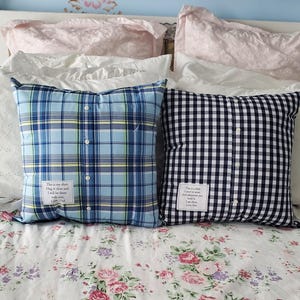 Two square throw pillows made from repurposed shirts. One is blue plaid, the other black and white gingham. Each pillow has a button-down front and a small white tag with text.