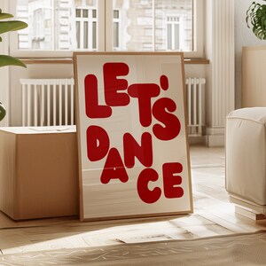 May include: A framed poster with the text "LET'S DANCE" in large, red, stylised letters on a white background.