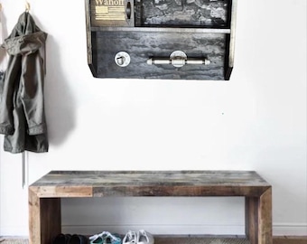 May include: A rustic wooden wall-mounted shelf with a drawer and a small compartment. The drawer has a metal handle and a small lock. The word "Wahoff" is printed on the top left, with an American flag design. A wooden bench and shoes are below.