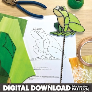 May include: A printable pattern for a stained glass frog. The pattern is numbered 1 through 20 and includes a line drawing of a frog sitting on a stem. The text "Print Your Own Pattern" is at the bottom of the page.