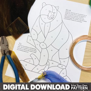 May include: A printable pattern for a stained glass bear. The pattern is numbered with 34 pieces. The text "BEAR" is at the top of the page, with instructions for assembling the stained glass project. The text "Tip" is at the bottom of the page, with instructions for printing and laminating the pattern.