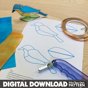 May include: A stained glass bird in blue, yellow, and green sits on a wooden surface next to a pattern, glass pieces, and tools. The pattern includes bird outlines and the text "DIGITAL DOWNLOAD Print Your Own PATTERN".