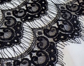 May include: Black lace trim with a scalloped edge and delicate floral pattern.