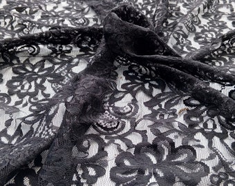 May include: Black lace fabric with a floral pattern. The lace is delicate and has a soft, flowing texture.