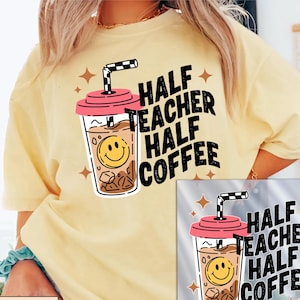 May include: A pale yellow t-shirt featuring a graphic of an iced coffee cup with a pink lid, a black and white checkered straw, and a yellow smiley face. The text reads HALF TEACHER HALF COFFEE in bold black letters, surrounded by small brown stars.