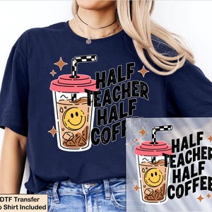 May include: A navy blue t-shirt featuring a graphic of an iced coffee cup with a pink lid, a black and white checkered straw, and a yellow smiley face. The text reads "HALF TEACHER HALF COFFEE" in bold black letters, surrounded by small orange stars.