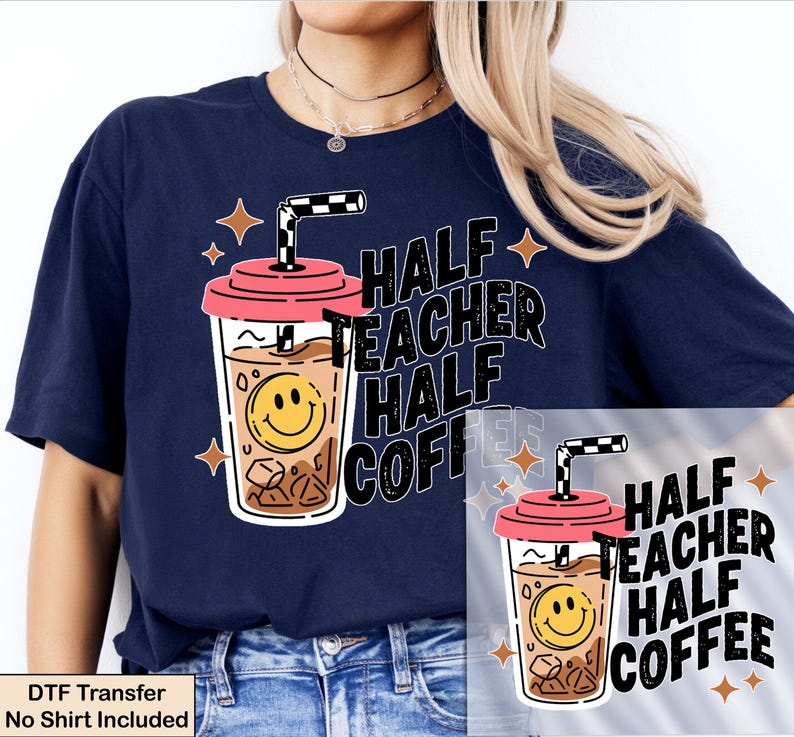 May include: A navy blue t-shirt featuring a graphic of an iced coffee cup with a pink lid, a black and white checkered straw, and a yellow smiley face. The text reads "HALF TEACHER HALF COFFEE" in bold black letters, surrounded by small orange stars.