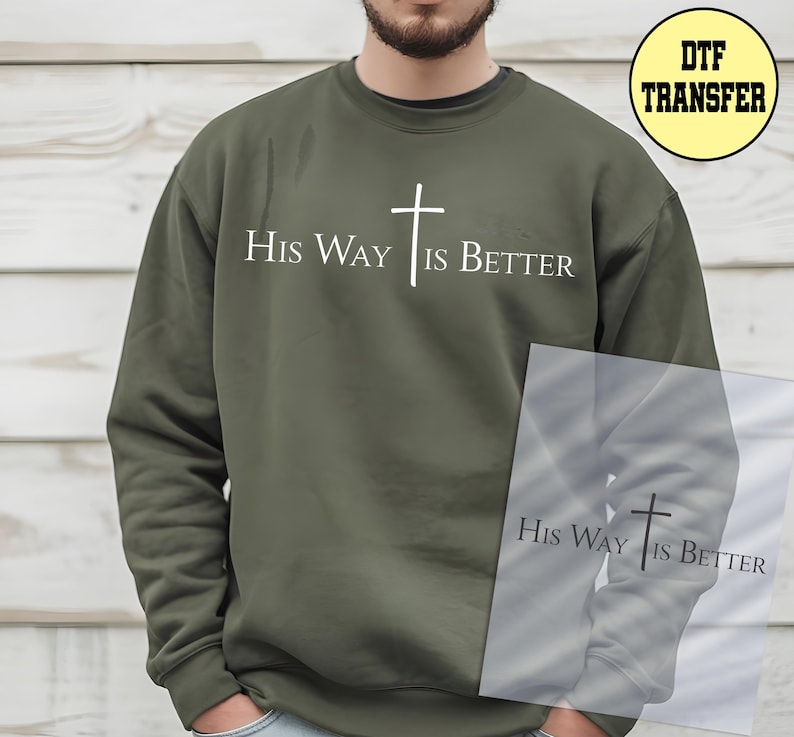 May include: Olive green sweatshirt with the text "His Way Is Better" and a white cross graphic. The design is centered on the chest. The sweatshirt is a crew neck style.