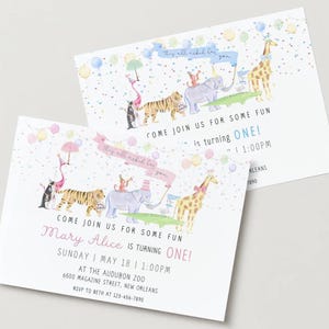 Könnte beinhalten: Zwei Einladungen mit einer skurrilen Illustration einer Parade von Tieren, darunter ein Tiger, ein Elefant und eine Giraffe. Die Einladungen kündigen eine erste Geburtstagsfeier mit dem Text "Komm mit uns Spaß haben" an.