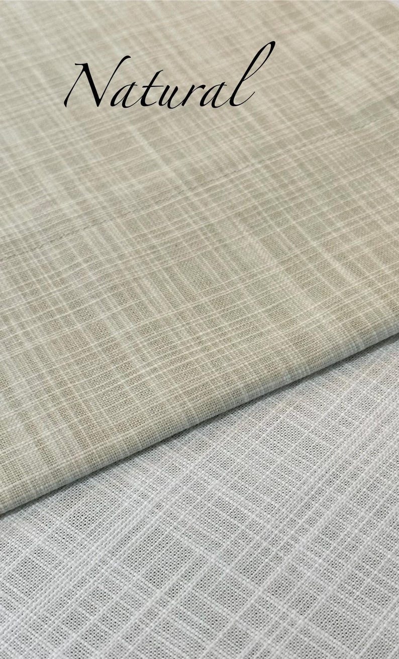 May include: Two pieces of fabric with a visible cross-hatch weave pattern. The top piece is a light beige colour with the word Natural printed in black script. The bottom piece is a solid white colour. Both fabrics feature a textured grid design.