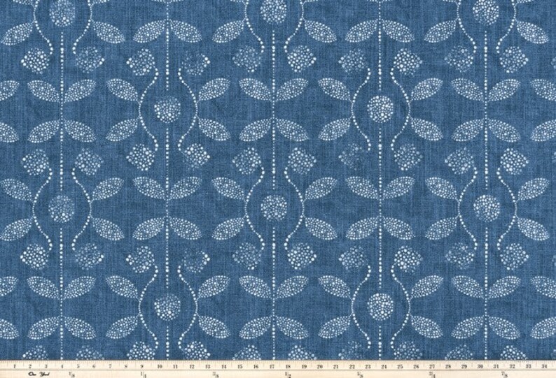 May include: A blue fabric with a white floral pattern. The pattern is made up of small dots that form leaves and flowers.