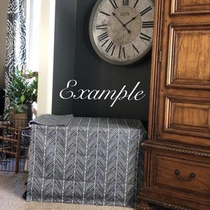 May include: A black and white chevron patterned table skirt with a large, antique-style clock with Roman numerals and the text "1879" on the face. The clock is hanging on a dark wall.