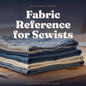 May include: A stack of folded fabric swatches in shades of blue and cream. The text reads: THE HATLEY STORE, Fabric Reference for Sewists, WOVENS, KNITS & CHOOSING CLOTH, FIBER CONTENT, NEEDLES & THREAD, ILLUSTRATED SEWING EGUIDE. Metal scissors are visible.