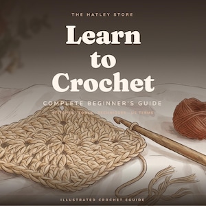 Può includere: Una guida illustrata intitolata The Hatley Store Learn to Crochet Complete Beginner's Guide. L'immagine mostra un quadrato lavorato all'uncinetto in filato color marrone chiaro, un uncinetto in legno e un gomitolo marrone su sfondo in tessuto chiaro.