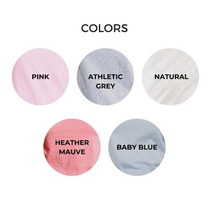 May include: Image displaying five color swatches: pink, athletic grey, natural, heather mauve, and baby blue. The word "COLORS" is at the top of the image.