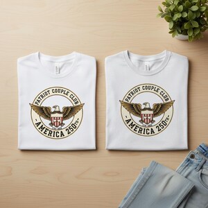 May include: Two white t-shirts with a circular emblem featuring a spread-winged eagle, the text "PATRIOT COUPLE CLUB - AMERICA 250th" in a vintage design. The shirts are folded neatly on a light wood surface.