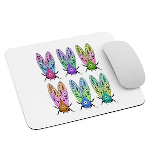 May include: White rectangular mousepad featuring a pattern of colorful, stylized insects with detailed wing designs. The insects are in various colors, including pink, purple, green, and orange. A white wireless mouse is positioned to the right of the mousepad.