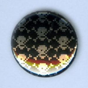 Könnte beinhalten: Ein schwarzer und silberner Knopf mit einem sich wiederholenden Muster aus weißen Totenköpfen und gekreuzten Knochen.